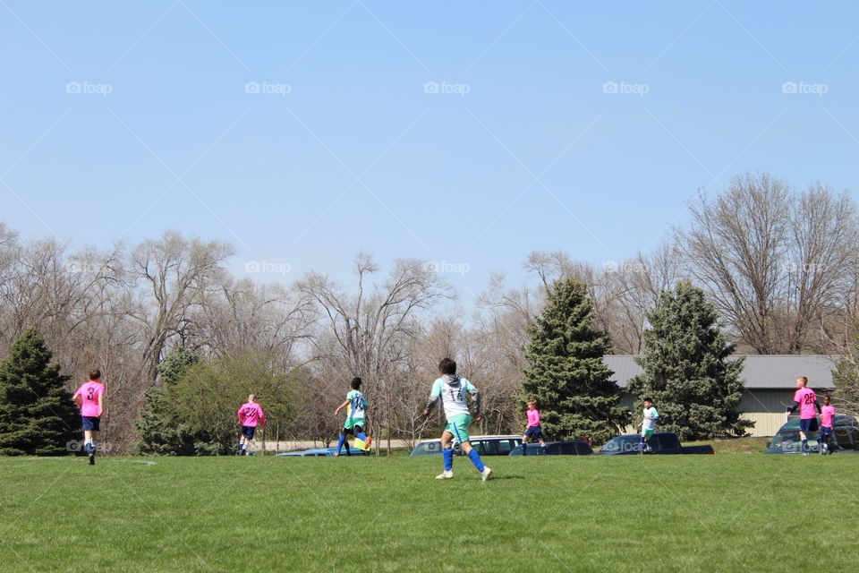 Kids playing soccer in a beautiful spring day.