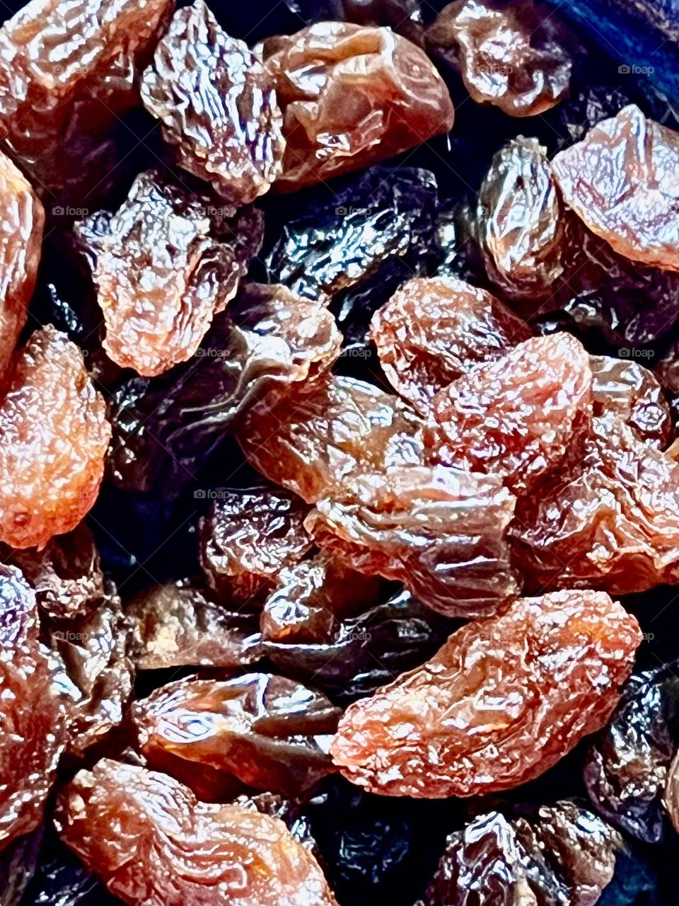 Raisins have a light brown, golden hue, with a translucent and shiny surface. Reminiscent of amber