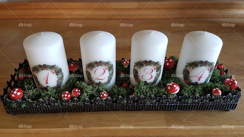 Advent candles with figures candlestick - adventsljusstake med vita ljus, siffror, grön mossa och flugsvampar på träbord