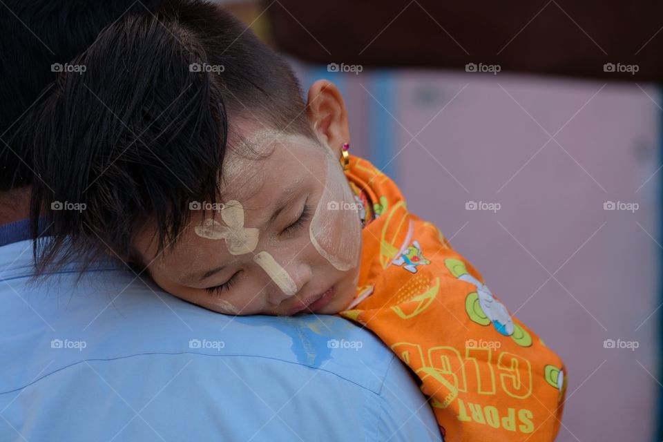 Myanmar kid’s sleeping on father’s shoulder