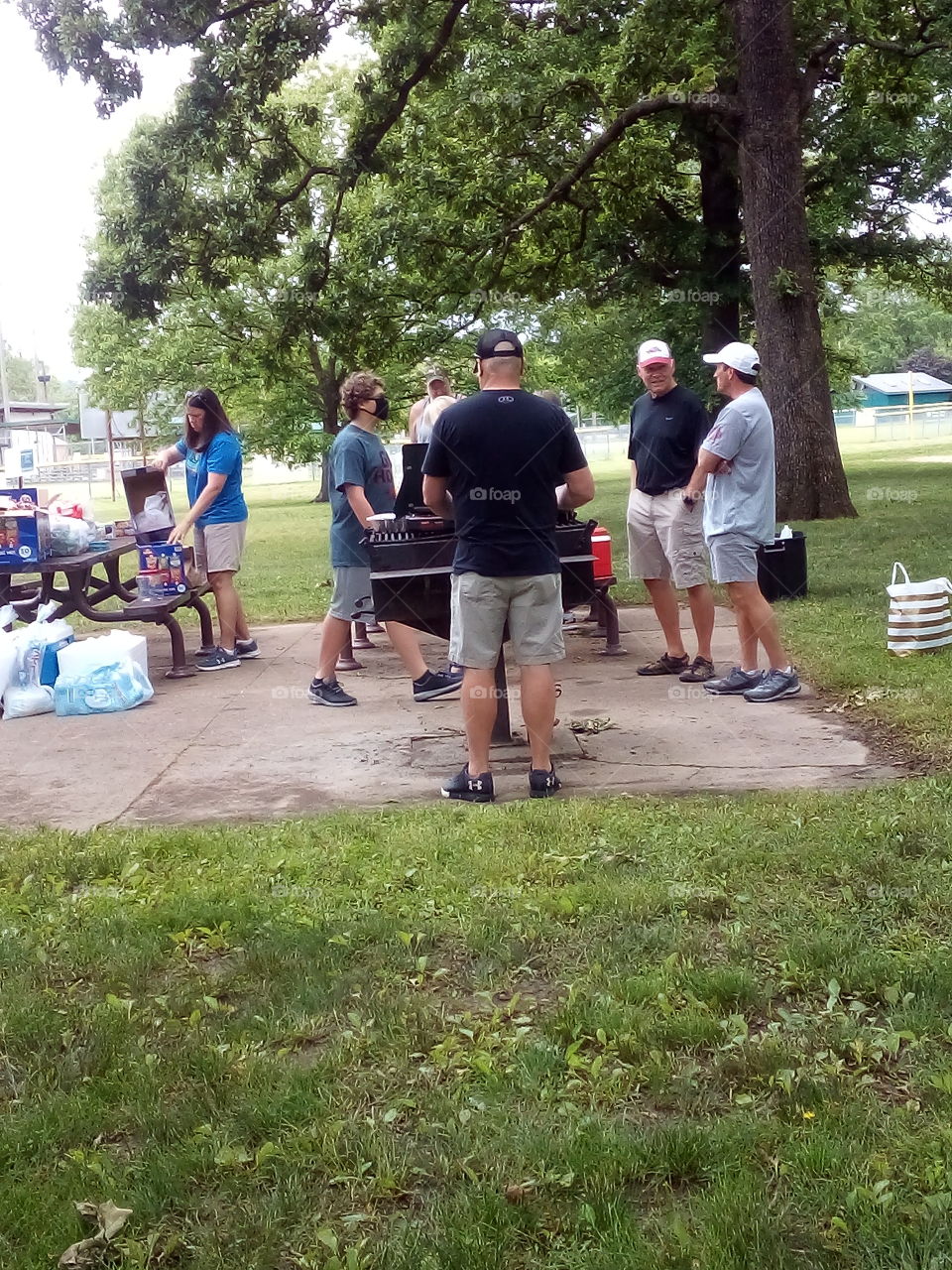 preparing the meal for Memorial day for all who are hungry. hotdogs and brats on the grill.