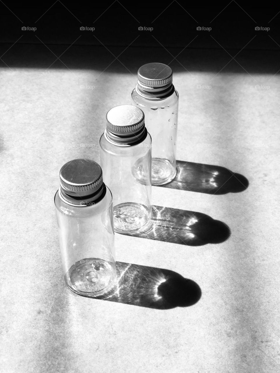 Black and white Shadow of three empty bottles on the floor crests most effective picture 