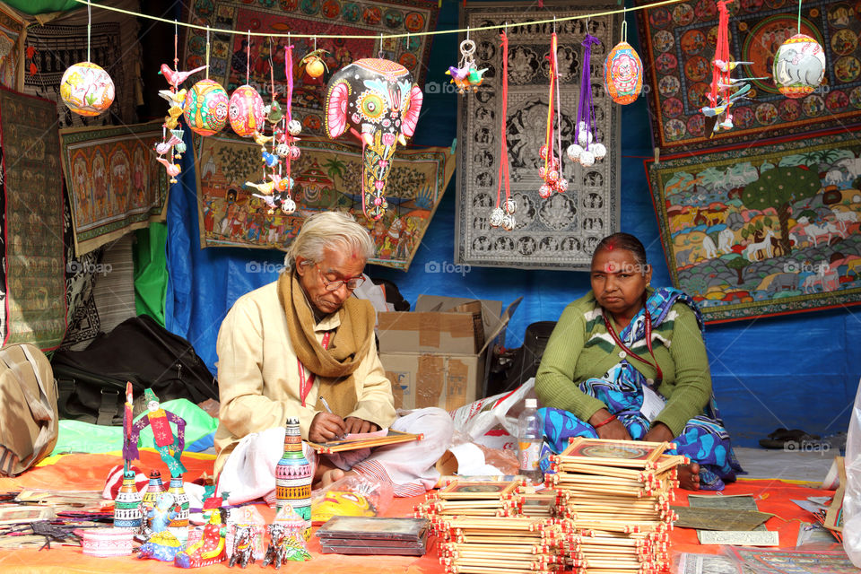 Old couple artist making and selling their handicraft art in surajkund mela, faridabad, haryana, india