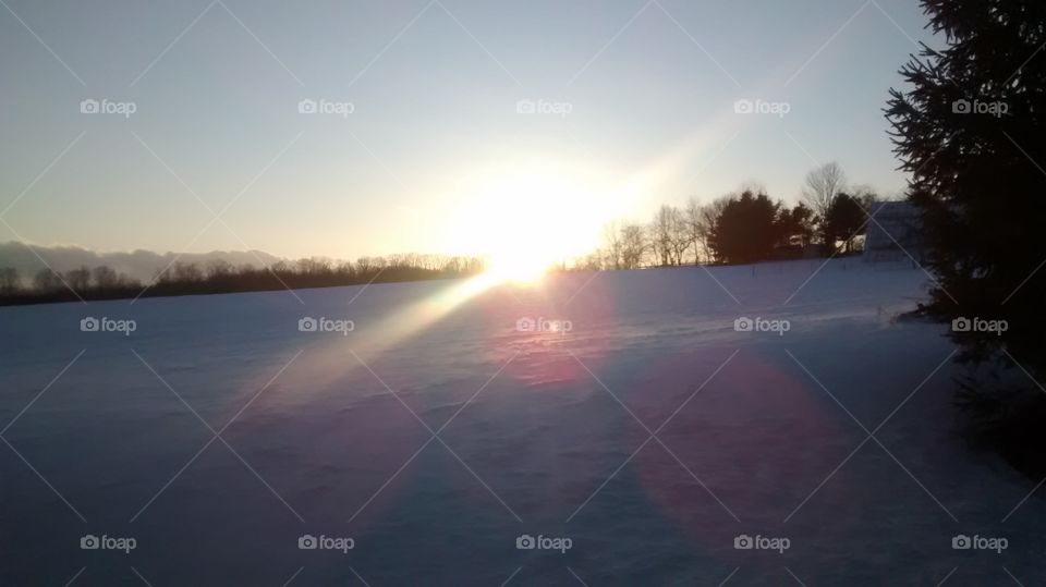 sunset. sun setting over a field of snow