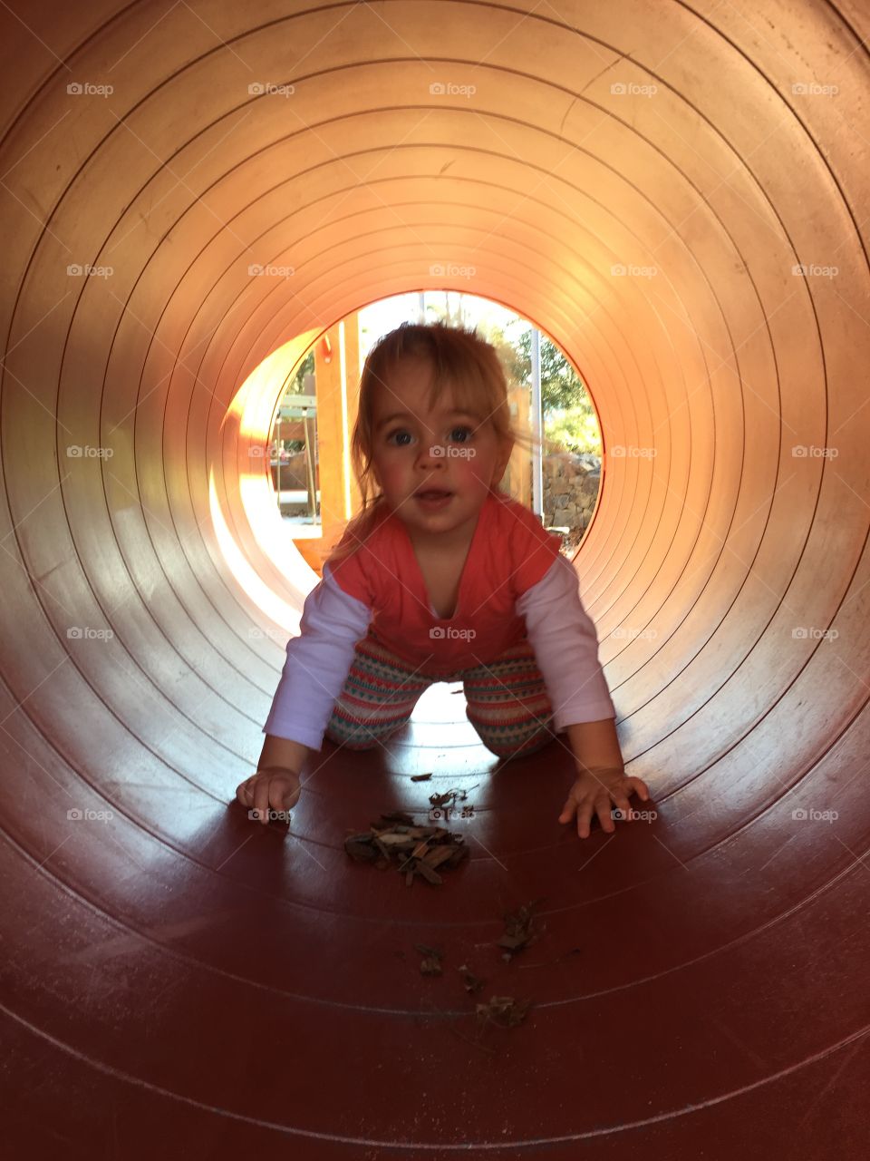 Small girl playing in tunnel