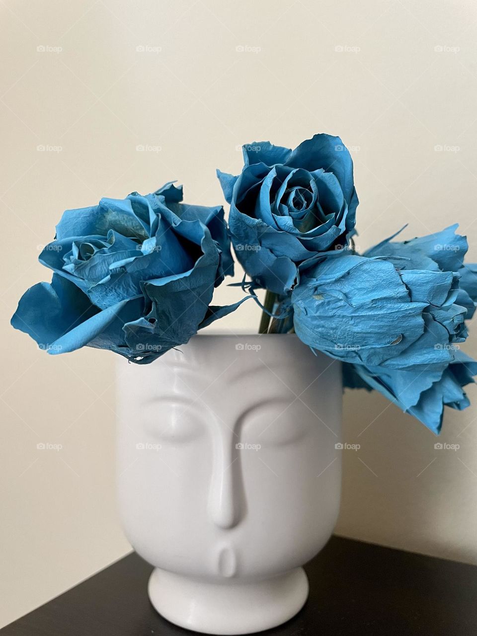 Blue dry roses in white vase