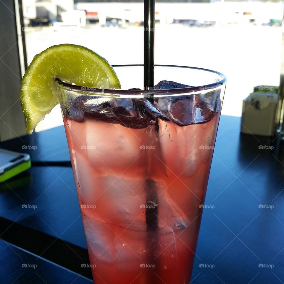 pink beverage in clear glass with lime slice