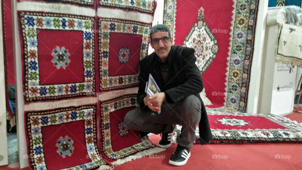 I m sitting beside beautiful moroccan coloruful carpet.