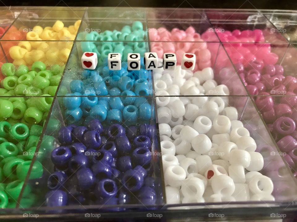 Decorating and spelling out the word Foap with beads 