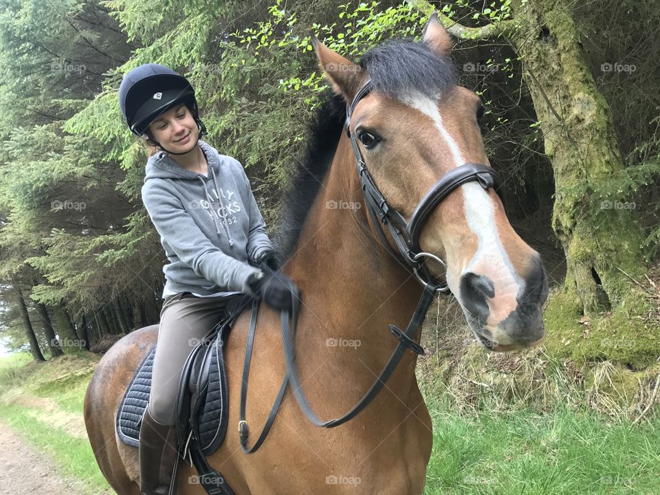 Girl on horse giving him a pat. 