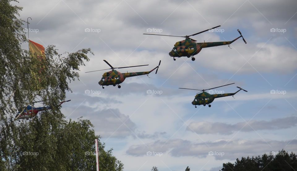 The helicopter is flying against the blue sky.