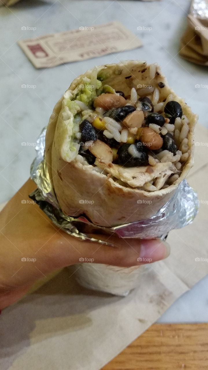 A simple and healthy burritos roll with beans, rice, avocado and cheese