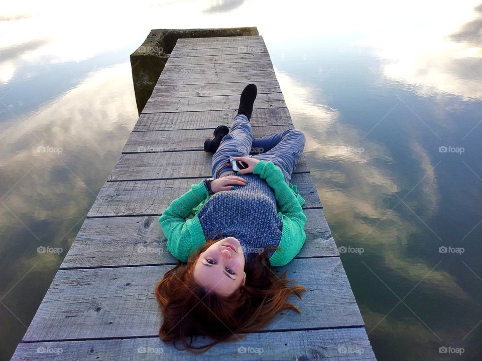 Stylish woman lying o wooden pier