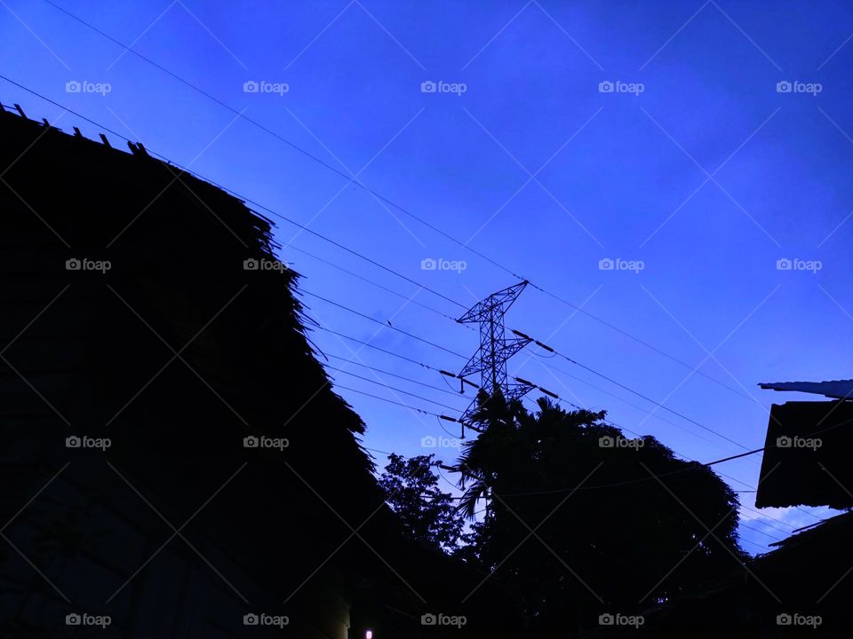 High voltage transmission towers with 
blue sky background at afternoon.