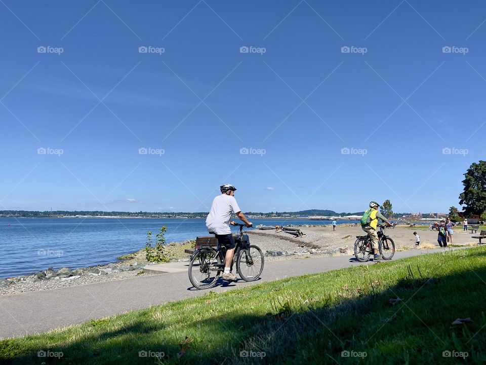 People riding bicycles near the river 