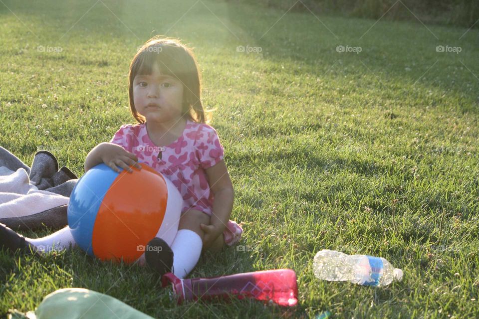 Little asian girl in park with ball