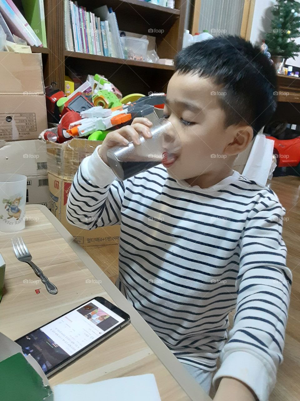 busy watching of his fone while drinking coca cola