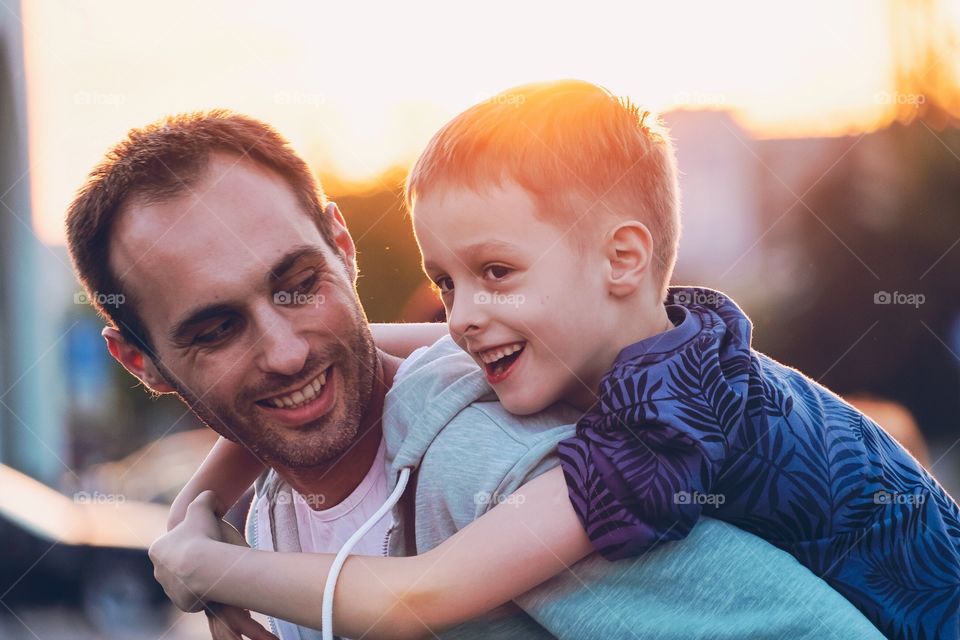 Happy smiling father and son at the sunset
