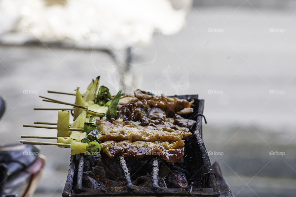 BBQ grilled meat with vegetables and tomato sauces on the steel grilles With the heat.