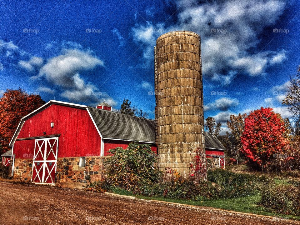 Red barn with silo surrounded by fall trees in MI