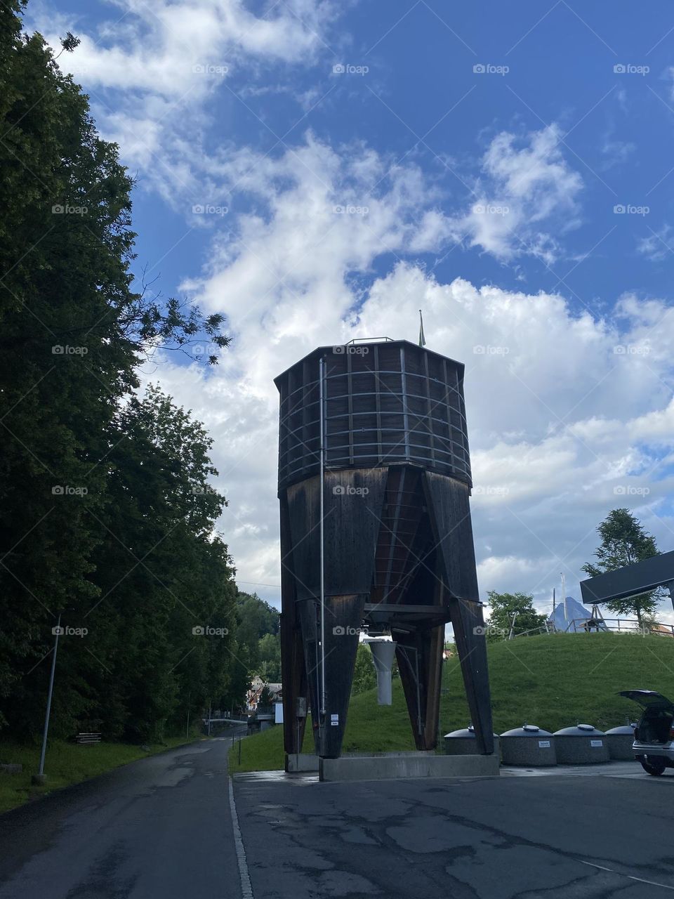 a large old wooden tower for grain or water against a blue cloudy sky