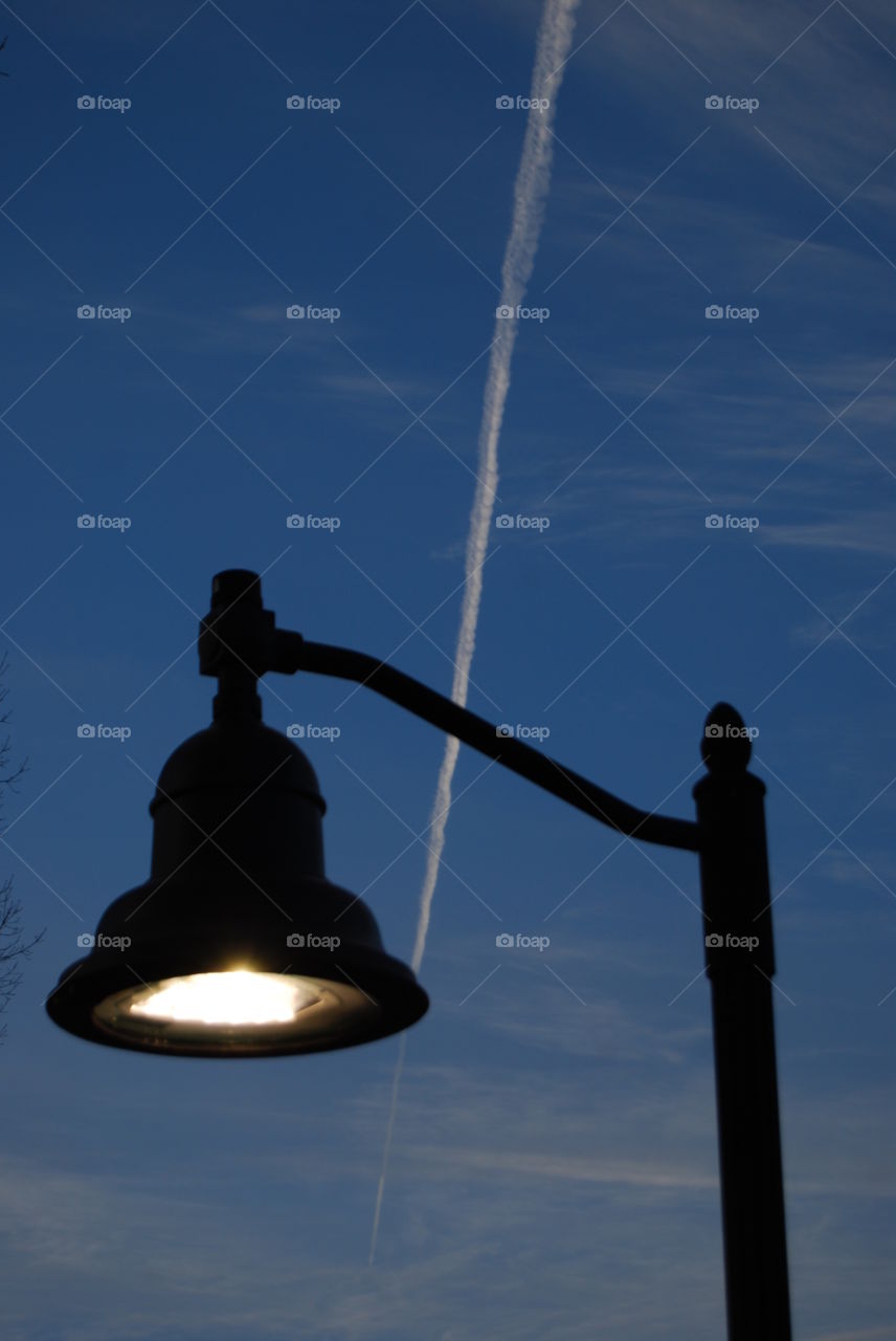 Street Lamp . Lamp post with a jet vapor in the background 