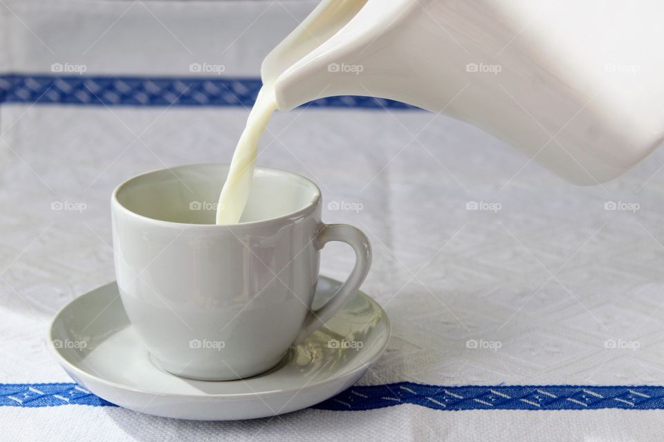 Putting milk in the white porcelain cup