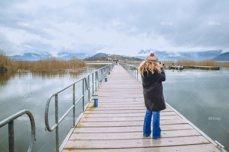 Beautiful Blonde Woman Photographer Standing On The Dock And Photographing Nature Landscape
