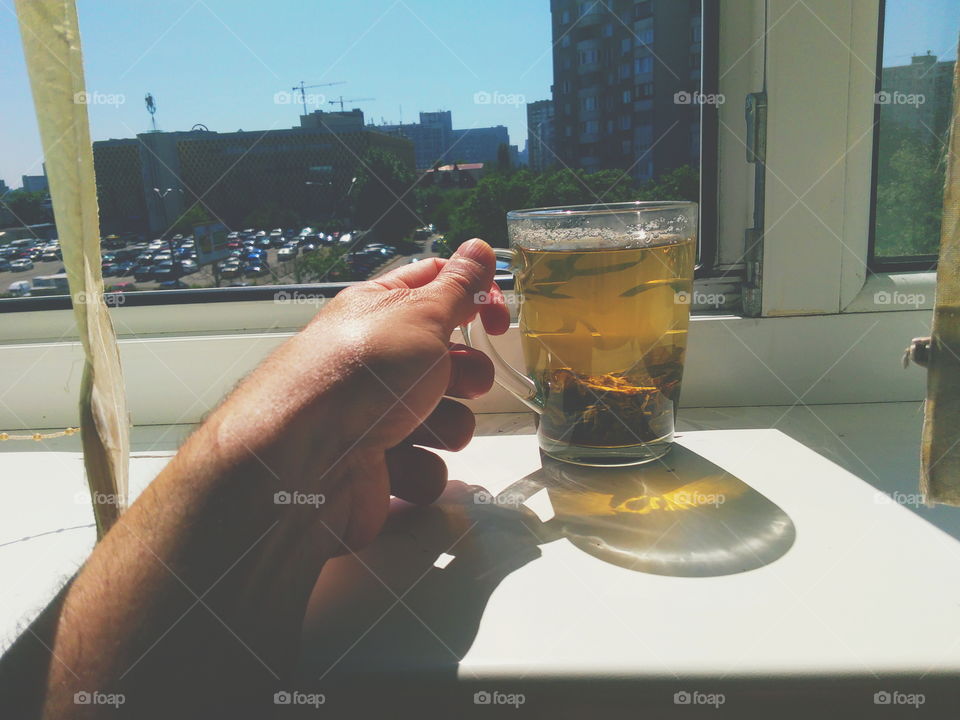 a cup of green tea is on the windowsill