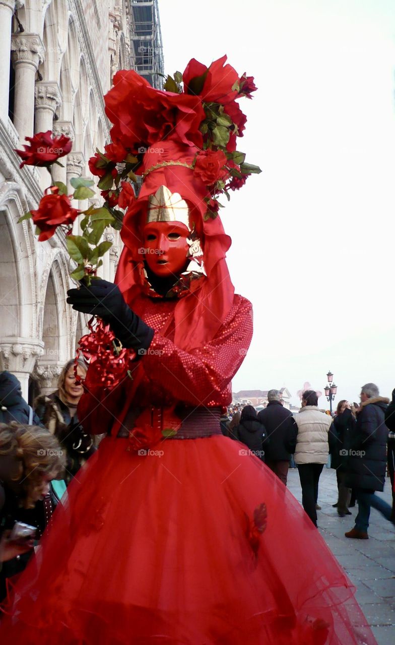 Red Venetian masks, red carnival costume in St Mark square 