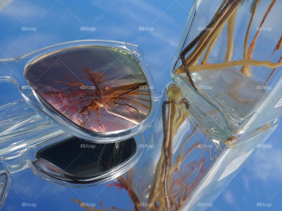 Flower vase reflected in sunglasses and mirror