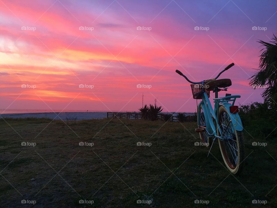 Bicycle on beach during sunrise