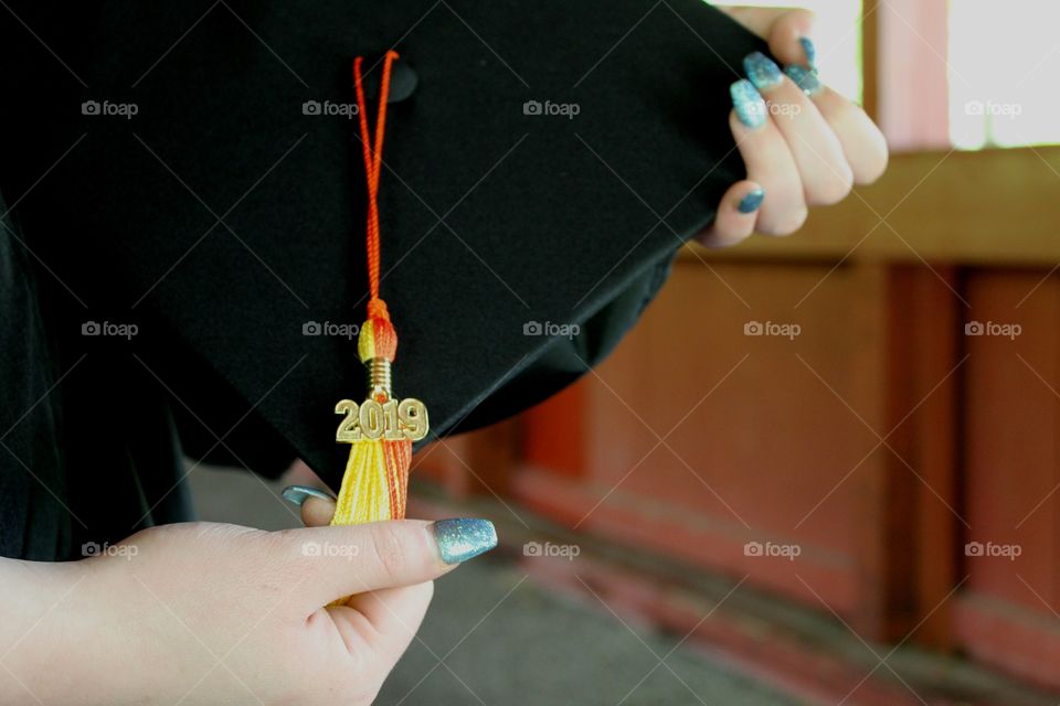 2019 High School Graduation Cap being Held by Feminine Hands with Glitter Nail Polish