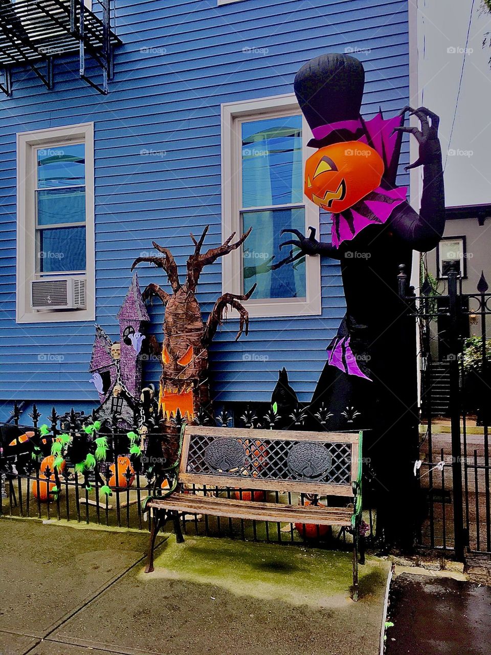 Halloween decorations incl. a gigantic blown up paper “Jack O’Lantern” are up outside this fenced off Fort Greene, Bklyn, NY property with garden that does, however offer a seat to passers-by on a bench outside the fence. 2020. Hypnotic Productions