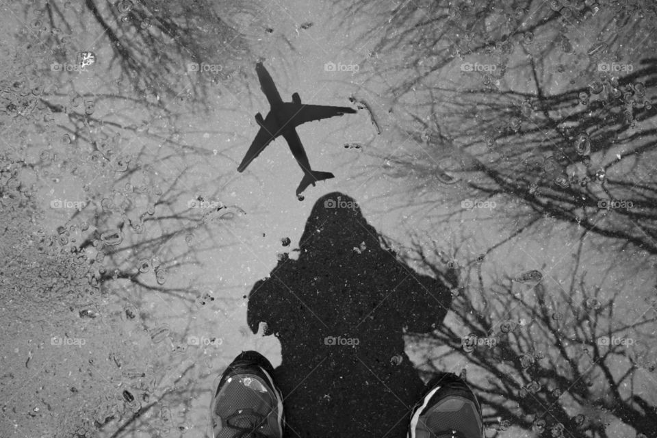 Reflection of person and aero plane in puddle