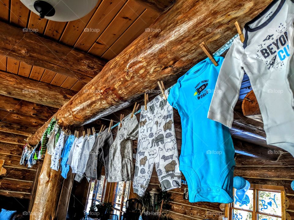 cute baby boy clothes hanging with rustic setting