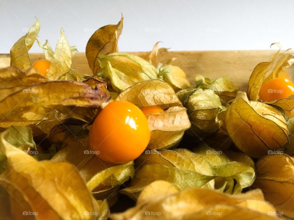 Bunch of cape gooseberries or physalis on a wooden bowl