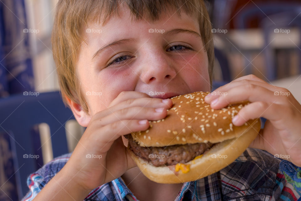 boy eating tasty cheeseburger