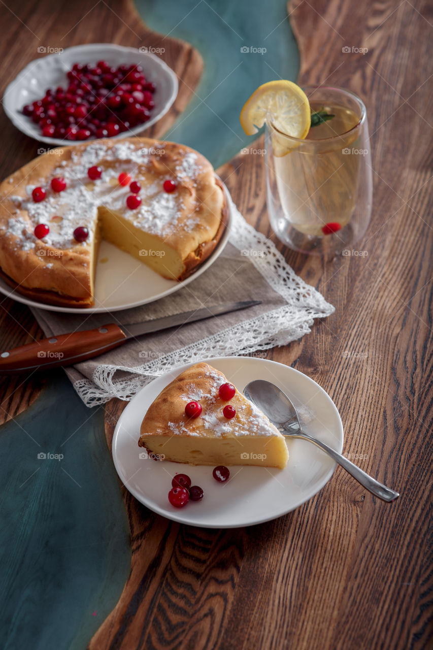 Cheesecake with cranberries and sugar on wooden background