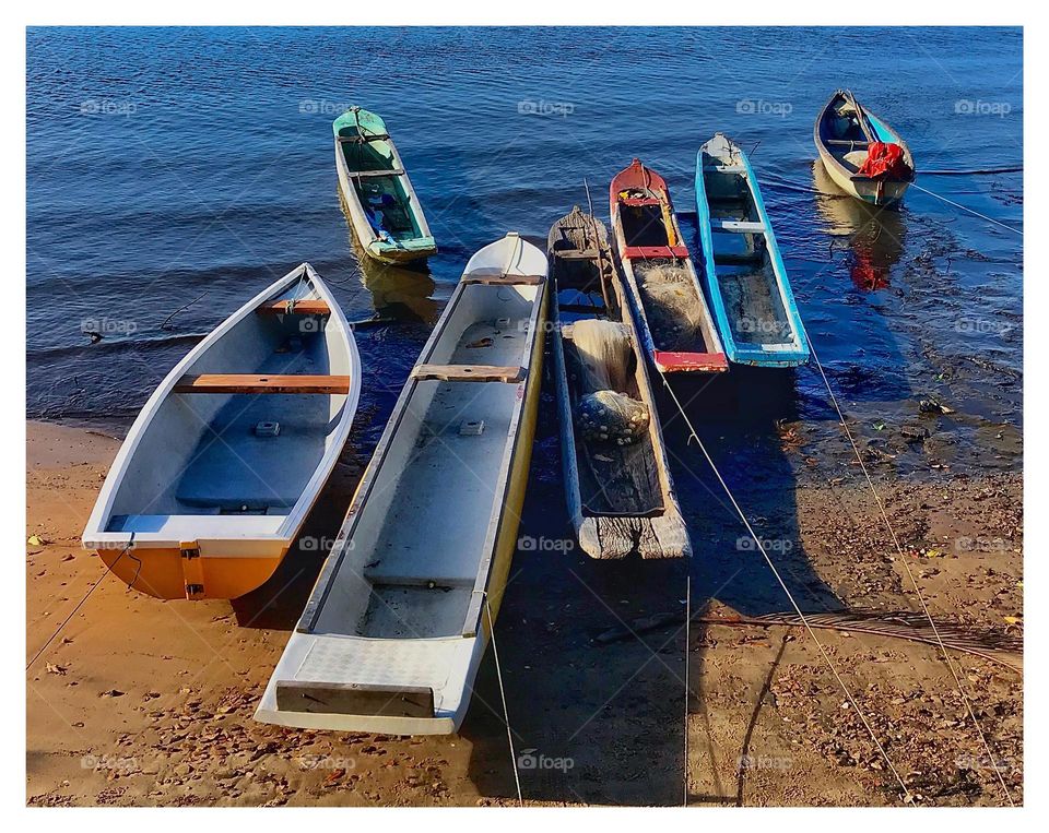 colorful canoes on the bank of the Jaguaripe river, Bahia, Brazil