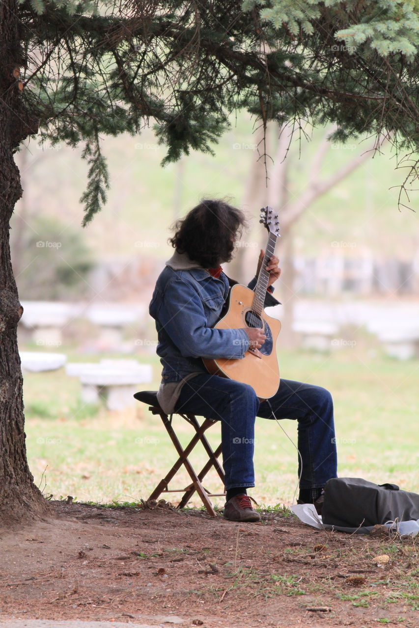 musician playing guitar in the park