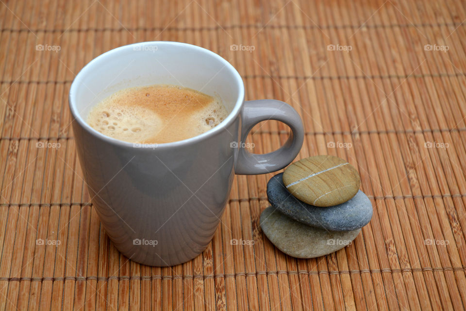 cup of coffee on a wooden bamboo background with zen cairn stones