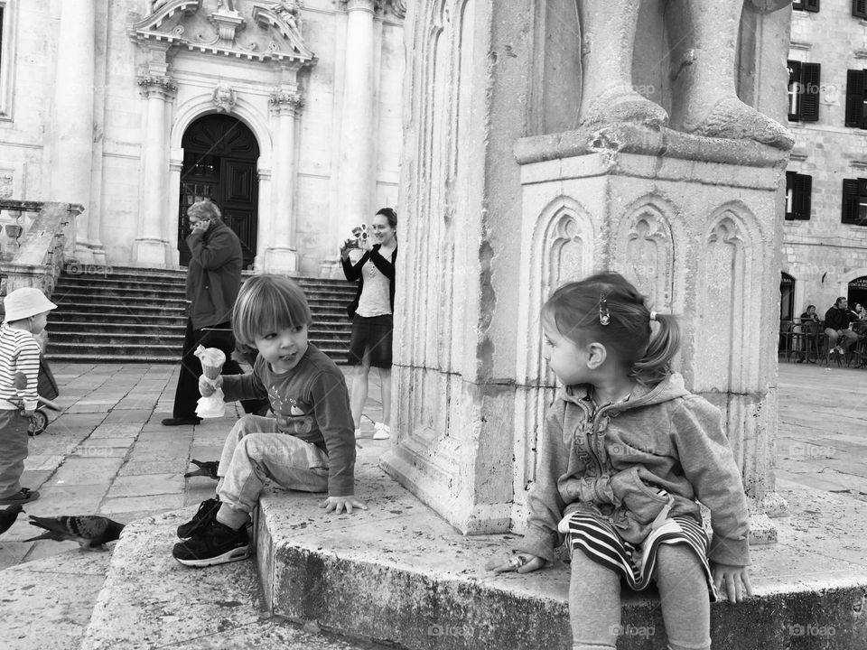 Boy eating ice cream and little girl watching in Old Town Dubrovnik, Croatia 