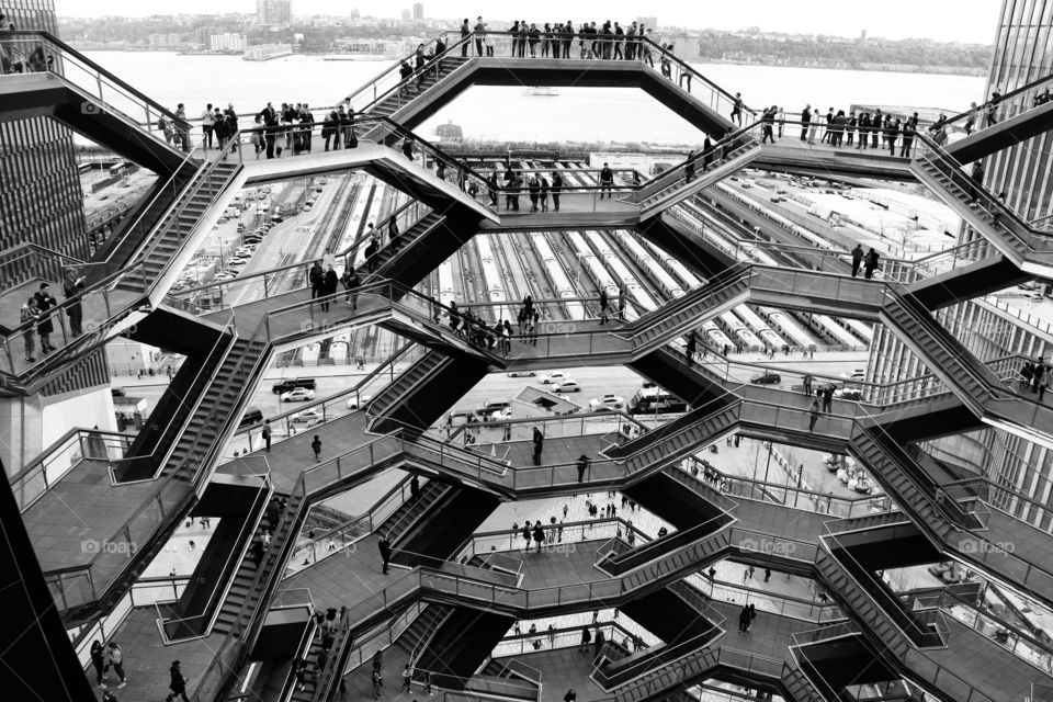 The Vessel, NYC. Modern architecture , black and white .. Staircases connected with platforms to look out .. crowds  watching the beauty of the cityscape from different angles and heights 