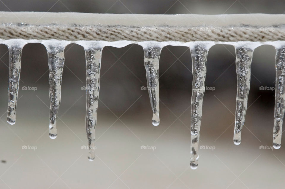 Icicles hanging from a clothesline on a winter day after an ice storm