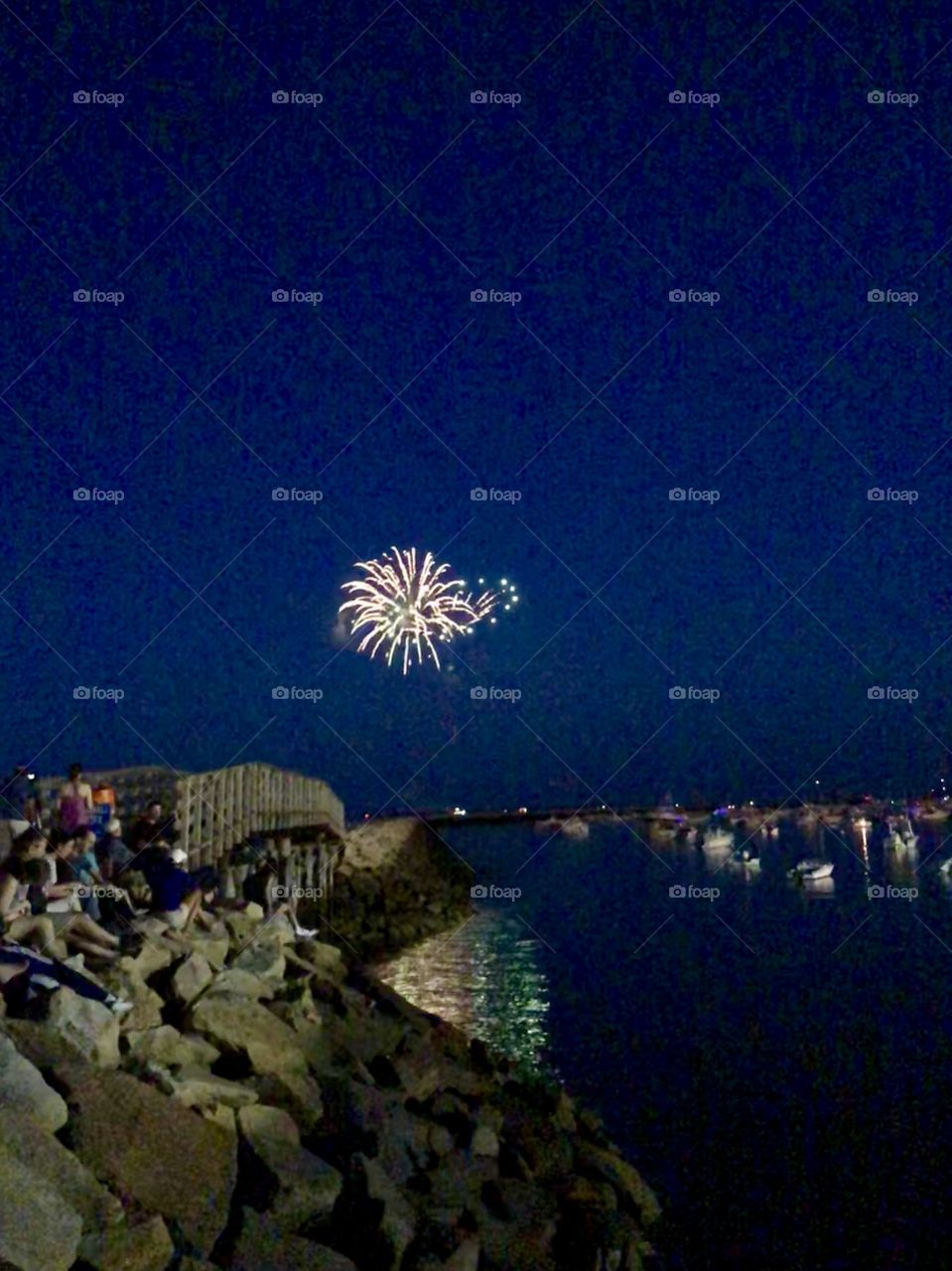Fireworks display over the jetty and harbor on the evening of the Fourth of July 