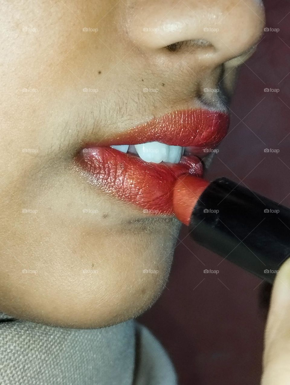 A girl coloring red lipstick
