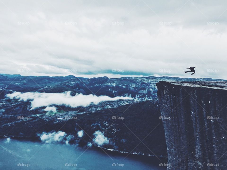 Jumping silhouette on the top of Prekestolen rock, Norway. 