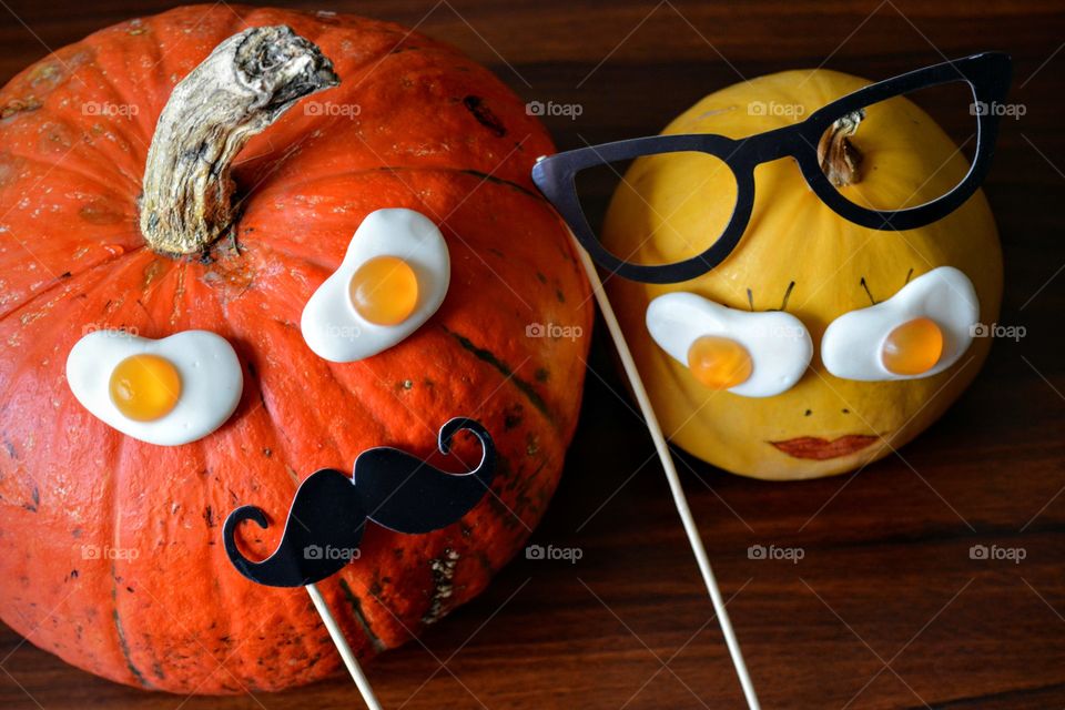 two pumpkins Halloween faces wooden background