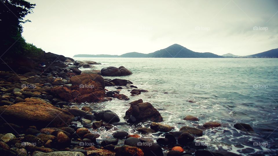Pedras, rochas à margem da praia.